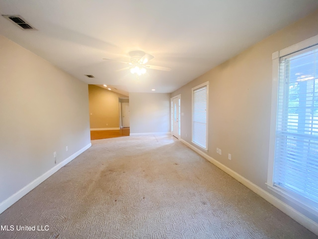 carpeted spare room with ceiling fan