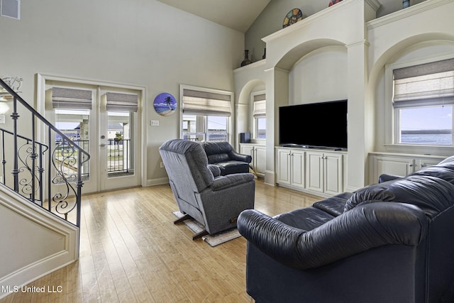 living area with a healthy amount of sunlight, stairway, visible vents, and light wood-style floors