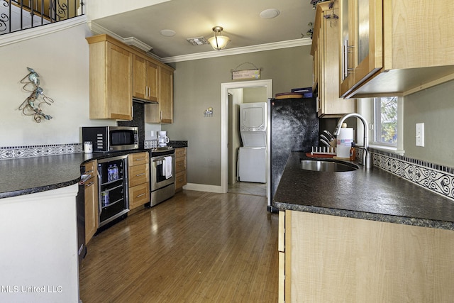 kitchen with wine cooler, a sink, ornamental molding, appliances with stainless steel finishes, and dark countertops