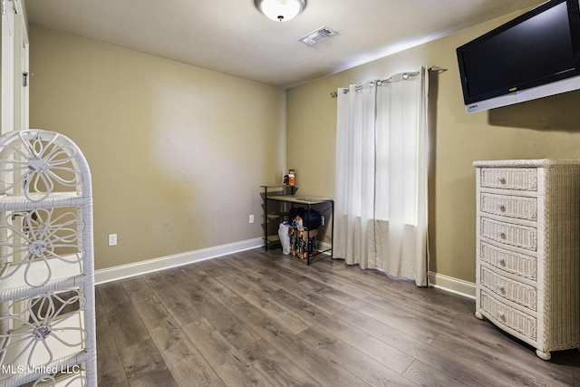 interior space with wood finished floors, visible vents, and baseboards