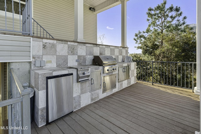 wooden deck featuring area for grilling and a grill