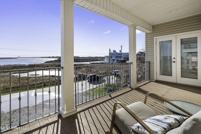 balcony featuring a water view and french doors