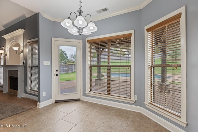 doorway with crown molding, light tile patterned floors, and a chandelier