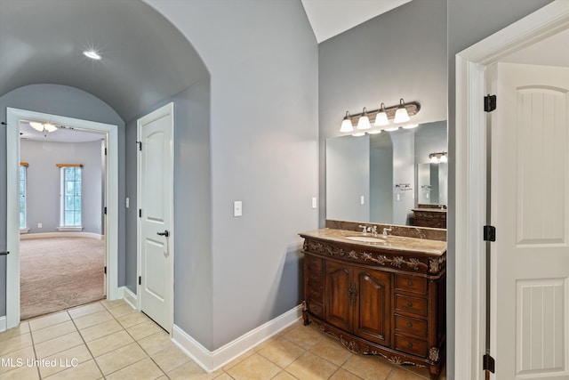 bathroom featuring tile patterned flooring, vanity, and lofted ceiling