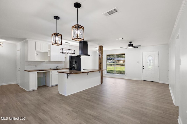 203 Bruin Ave, Pearl, MS 39208 - kitchen with black fridge, island exhaust hood, light wood-style floors, baseboards, and crown molding