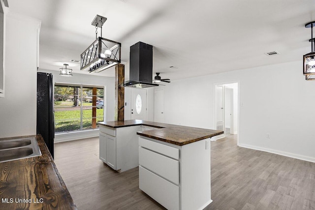 203 Bruin Ave, Pearl, MS 39208 - kitchen featuring wooden counters, island range hood, wood finished floors, and white cabinets