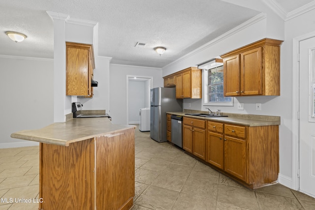 kitchen with a breakfast bar, sink, a textured ceiling, appliances with stainless steel finishes, and kitchen peninsula