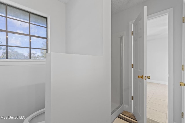 bathroom with tile patterned floors and a textured ceiling