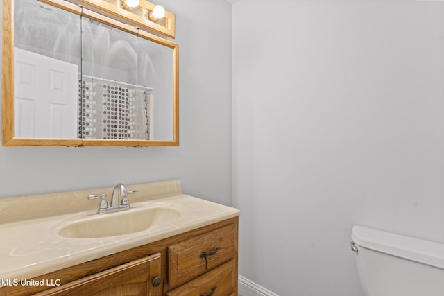 bathroom featuring a shower with shower curtain, vanity, and toilet