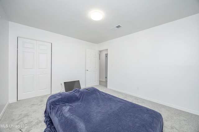 bedroom with light carpet and a closet