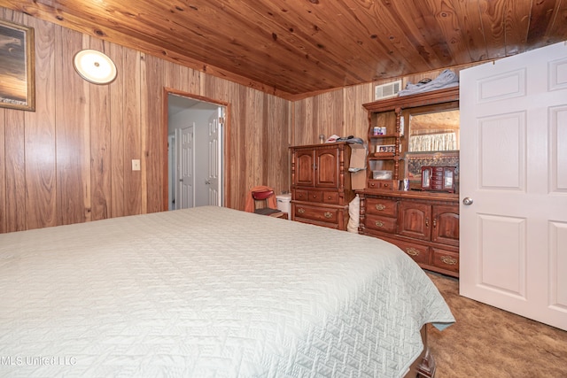 bedroom featuring carpet, wood walls, and wooden ceiling