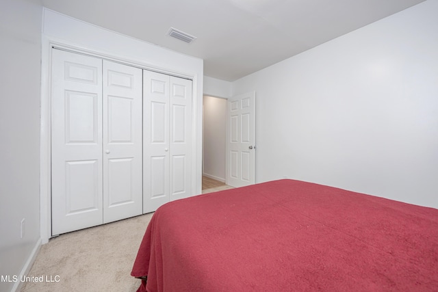 bedroom featuring a closet and light colored carpet