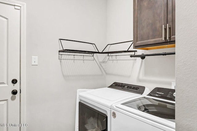 washroom with cabinets and washing machine and dryer