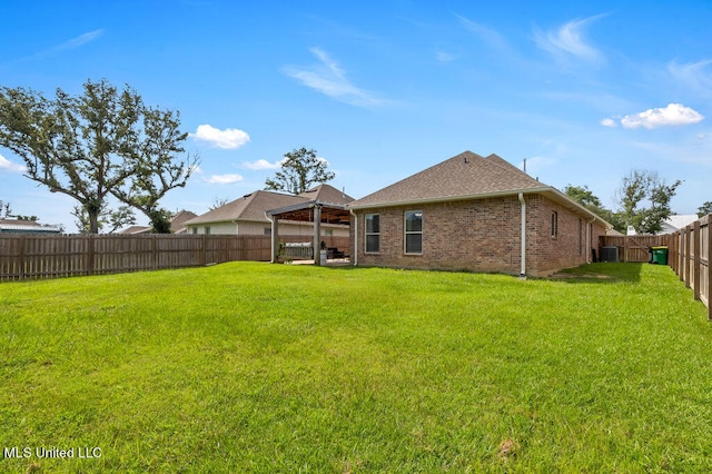 back of property featuring a yard and central AC