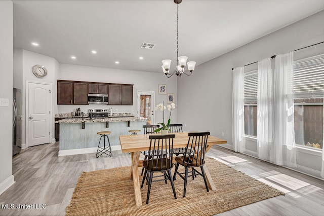 dining room with a chandelier and light hardwood / wood-style floors