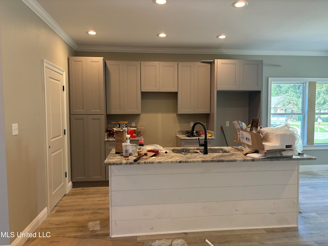 kitchen featuring light stone counters, sink, gray cabinets, and light hardwood / wood-style floors