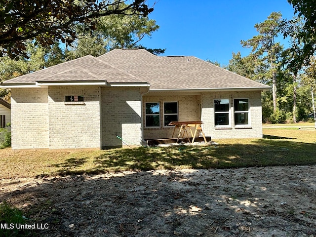 rear view of house featuring a lawn