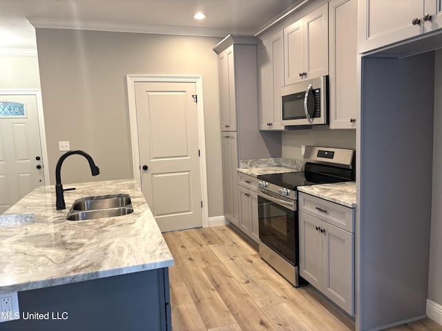 kitchen with appliances with stainless steel finishes, sink, ornamental molding, light hardwood / wood-style floors, and light stone countertops