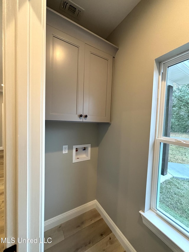 laundry area featuring hardwood / wood-style flooring, cabinets, and hookup for a washing machine