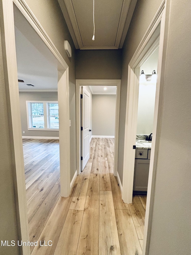 corridor featuring ornamental molding and light wood-type flooring