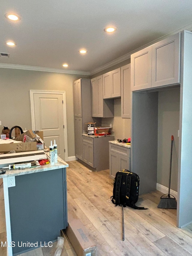 kitchen featuring ornamental molding, light hardwood / wood-style floors, and gray cabinetry