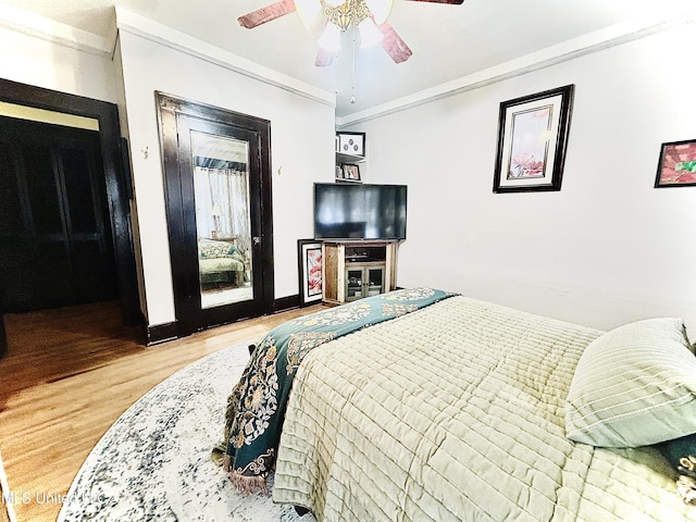 bedroom with ornamental molding, hardwood / wood-style flooring, and ceiling fan