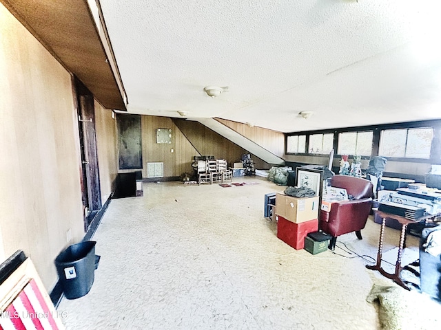 miscellaneous room featuring wooden walls and a textured ceiling