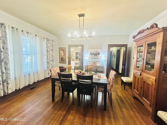 dining room with a notable chandelier, dark hardwood / wood-style floors, and crown molding