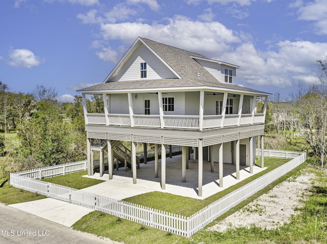 211 Chartres St, Bay Saint Louis, MS 39520 - rear view of house featuring a ceiling fan, a carport, a shingled roof, driveway, and a patio area