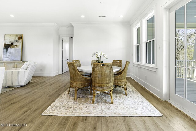 211 Chartres St, Bay Saint Louis, MS 39520 - dining room featuring baseboards, crown molding, wood finished floors, and recessed lighting