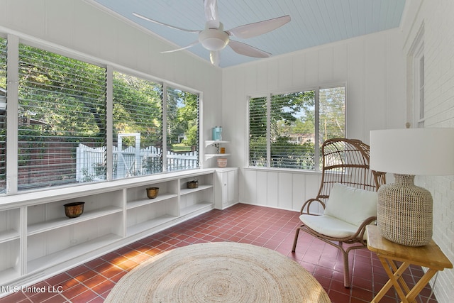 sitting room with dark tile patterned flooring, ceiling fan, and a wealth of natural light