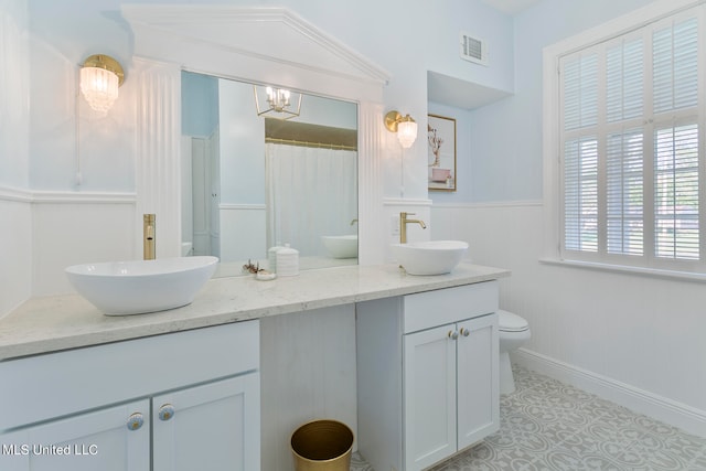 bathroom with an inviting chandelier, vanity, lofted ceiling, and toilet