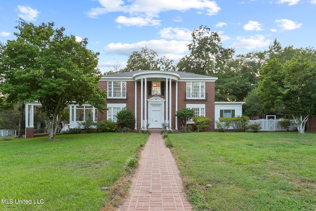 greek revival house featuring a front yard