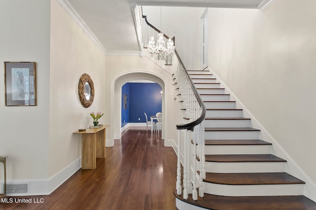 stairs featuring a notable chandelier, wood-type flooring, and ornamental molding