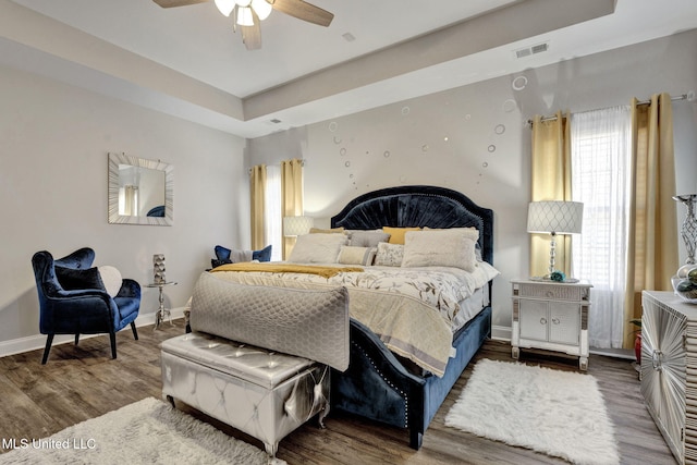 bedroom featuring a tray ceiling, hardwood / wood-style floors, and ceiling fan