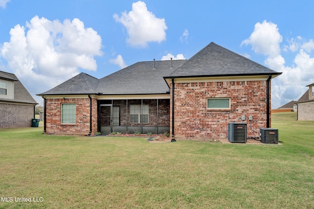 rear view of property featuring central AC unit and a yard