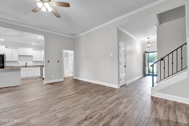 unfurnished living room featuring ceiling fan, sink, light hardwood / wood-style flooring, and crown molding