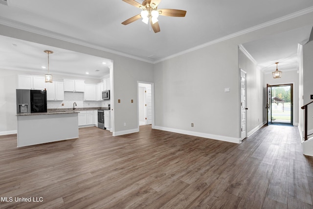 unfurnished living room featuring hardwood / wood-style floors, ceiling fan, crown molding, and sink