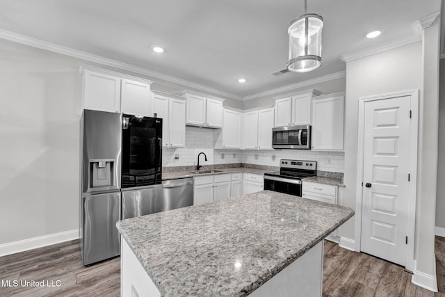 kitchen with stainless steel appliances, dark wood-type flooring, white cabinets, sink, and a kitchen island