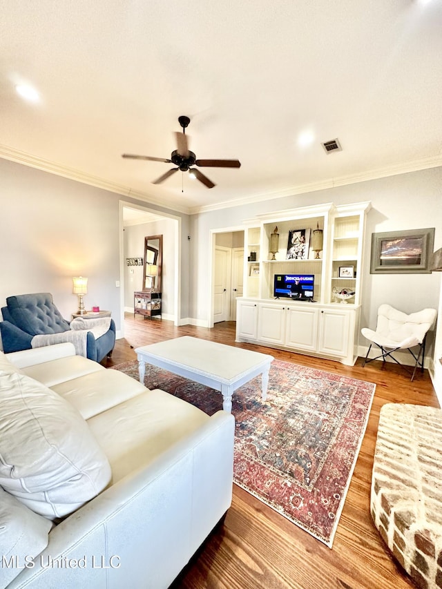 living room featuring hardwood / wood-style floors, ceiling fan, and crown molding