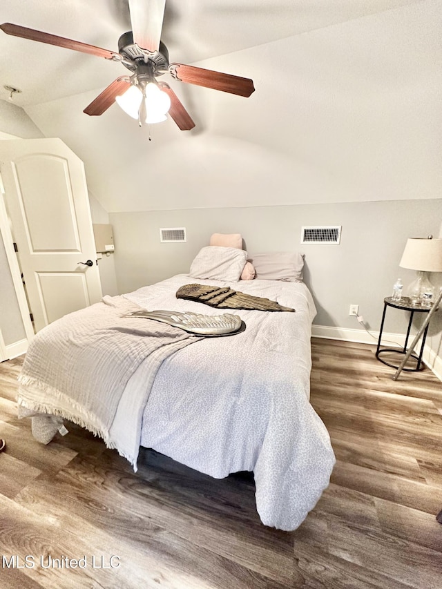 bedroom featuring ceiling fan, hardwood / wood-style floors, and vaulted ceiling