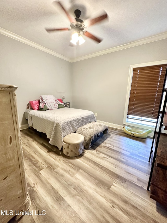 bedroom featuring ceiling fan, crown molding, light wood-type flooring, and a textured ceiling