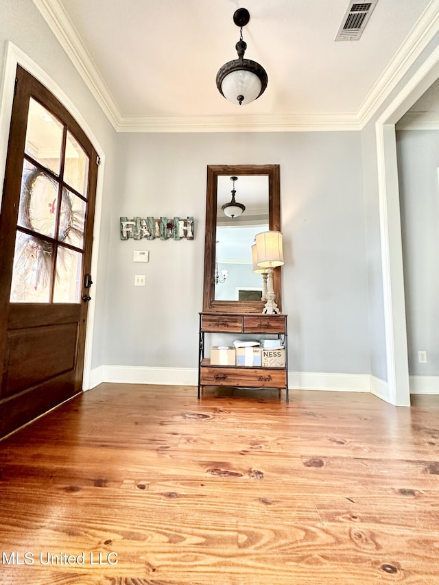 entrance foyer featuring hardwood / wood-style flooring and ornamental molding