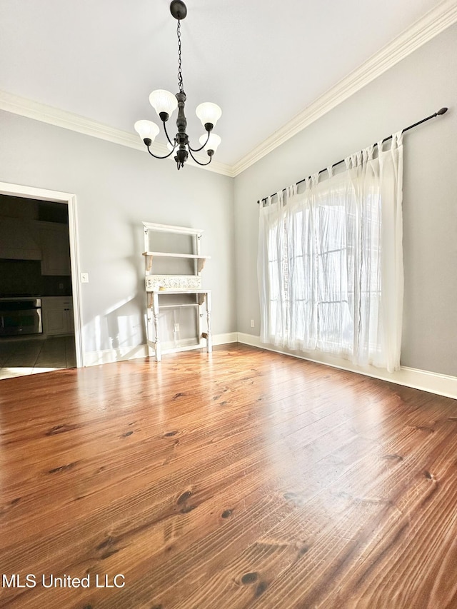 unfurnished dining area featuring hardwood / wood-style floors, a notable chandelier, and crown molding