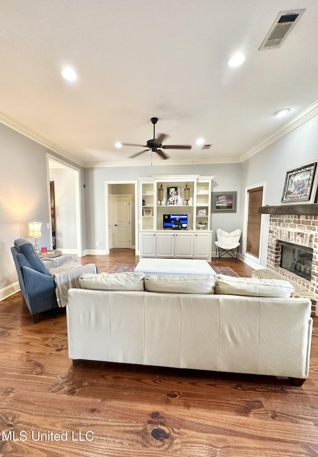 715 Tortoise Rdg, Brandon, MS 39047 - living area featuring crown molding, a brick fireplace, a ceiling fan, wood finished floors, and recessed lighting