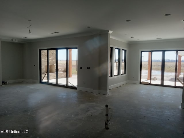 1400 Bayou Dr, Indianola, MS 38751 - unfurnished living room featuring unfinished concrete flooring, ornamental molding, and baseboards