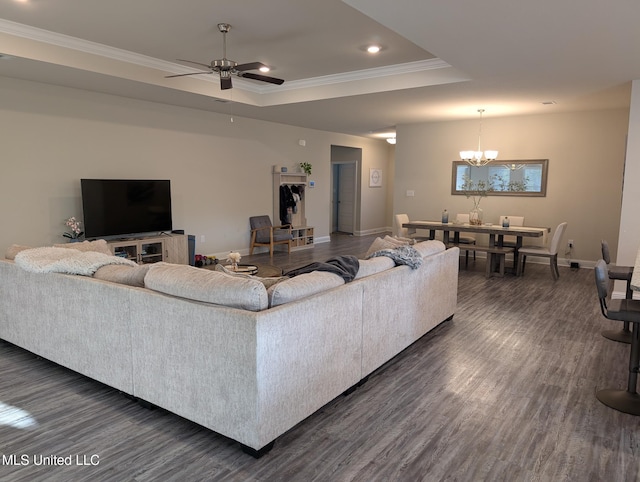 living room with a raised ceiling, dark wood-style floors, recessed lighting, crown molding, and baseboards