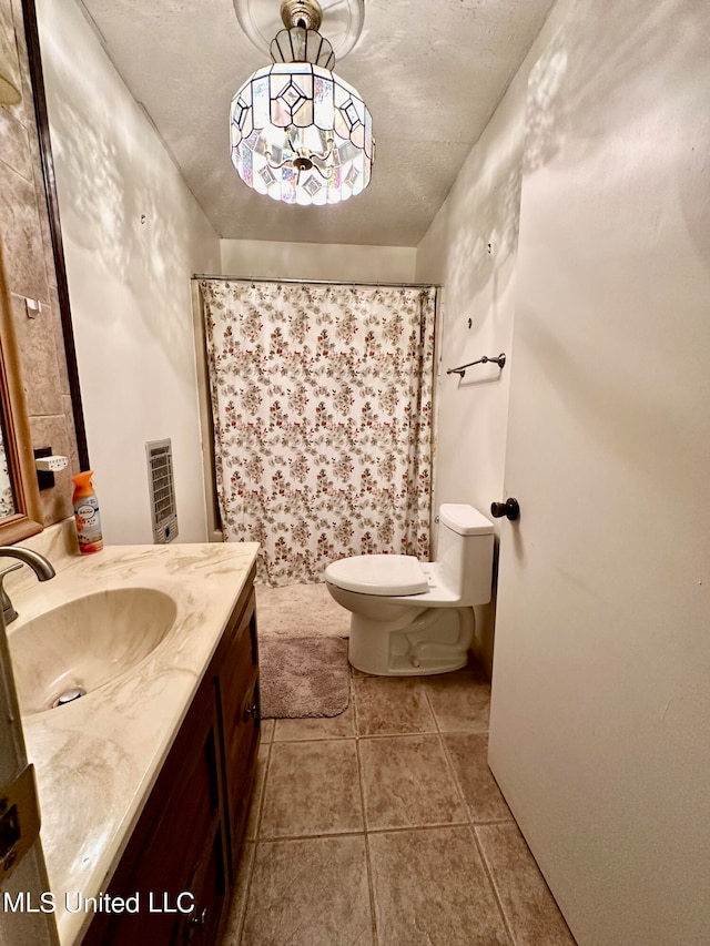 bathroom with a textured ceiling, toilet, walk in shower, vanity, and tile patterned flooring