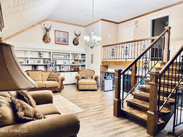 living room with light wood-type flooring, vaulted ceiling, crown molding, a chandelier, and built in shelves