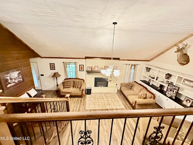 living room featuring crown molding, lofted ceiling, and an inviting chandelier